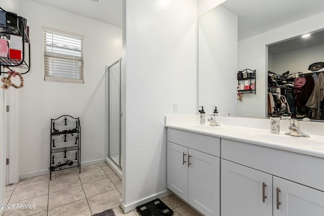 bathroom featuring tile patterned floors, a stall shower, and a sink