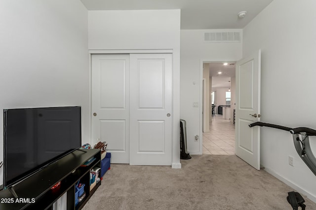 interior space with visible vents, light carpet, and a closet