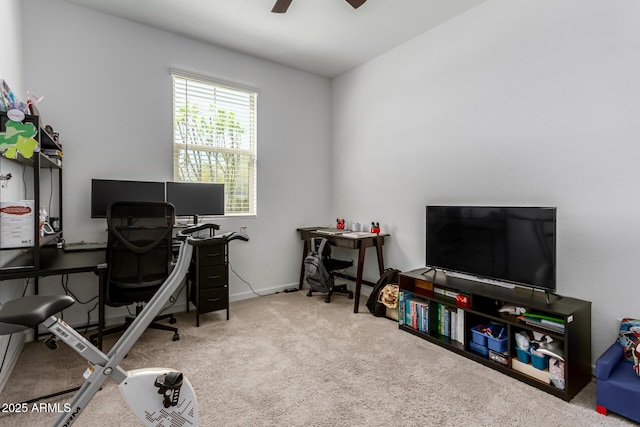 carpeted home office featuring baseboards and ceiling fan
