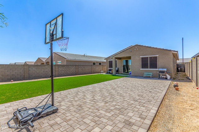 exterior space with a lawn, a patio area, stucco siding, and a fenced backyard