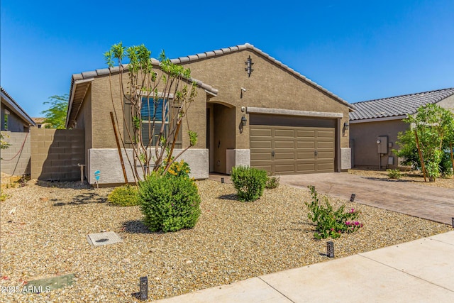ranch-style house featuring stucco siding, a tiled roof, fence, a garage, and concrete driveway