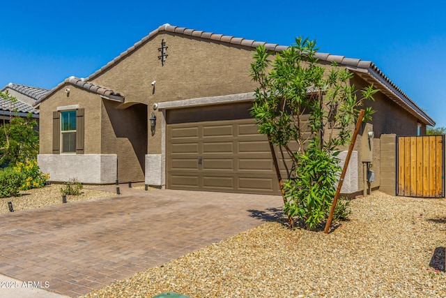 view of front of house with stucco siding, a garage, and a tile roof