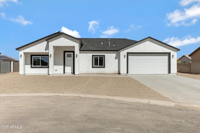 ranch-style home with a garage, a shingled roof, fence, concrete driveway, and stucco siding