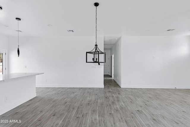 unfurnished living room featuring light wood-type flooring, visible vents, and baseboards