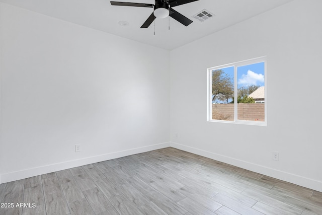 unfurnished room featuring ceiling fan, wood finished floors, visible vents, and baseboards