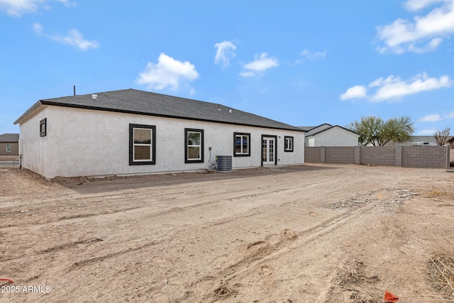 rear view of house featuring french doors, stucco siding, cooling unit, and fence