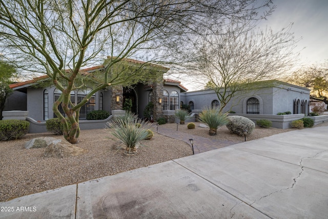 view of front of property with a tile roof and stucco siding