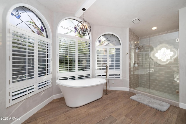 bathroom featuring a stall shower, a freestanding tub, and wood finished floors