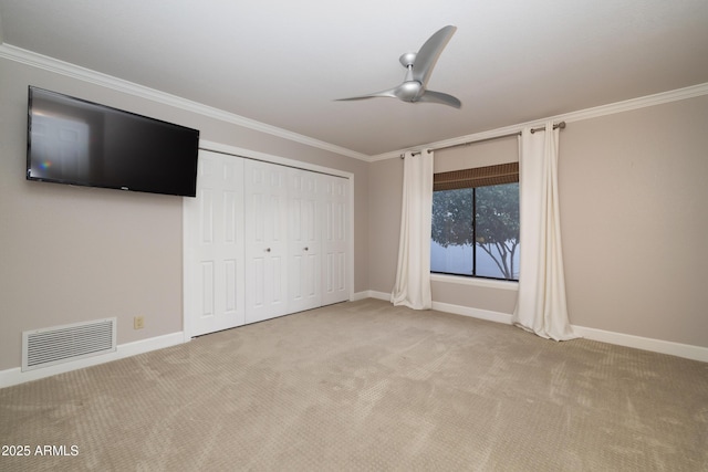 unfurnished bedroom with light carpet, baseboards, visible vents, and ornamental molding