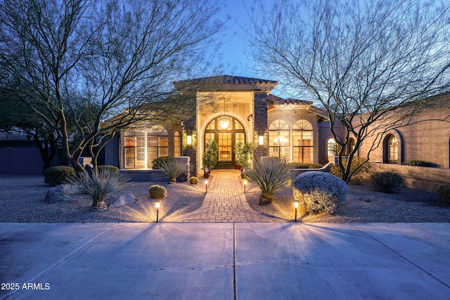 mediterranean / spanish-style house with french doors and stucco siding