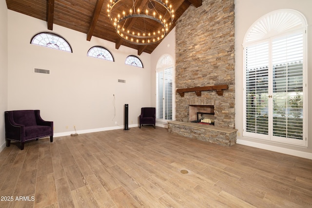 unfurnished living room featuring a fireplace, wood ceiling, high vaulted ceiling, light wood-type flooring, and baseboards