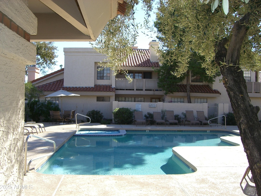 pool with a community hot tub and a patio