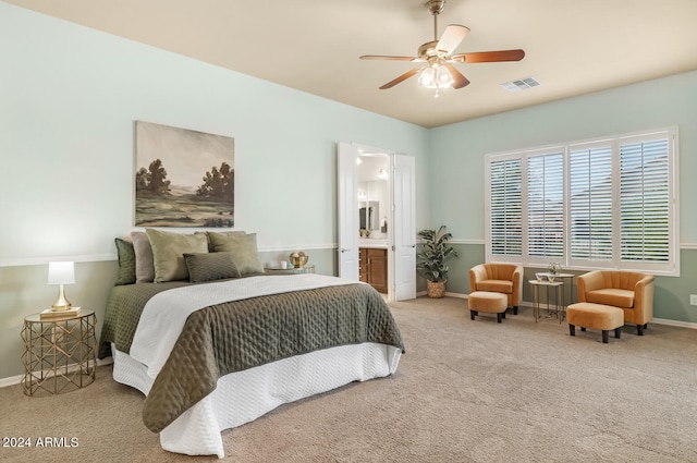 bedroom featuring light colored carpet, ensuite bathroom, and ceiling fan