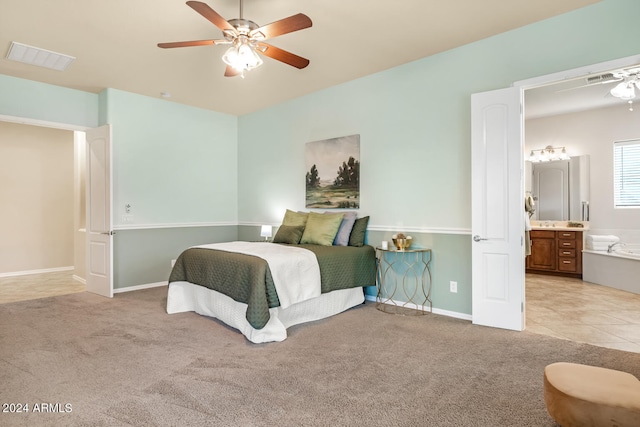 bedroom featuring ceiling fan, connected bathroom, and light colored carpet