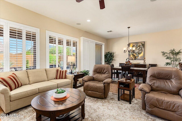 living room featuring ceiling fan with notable chandelier