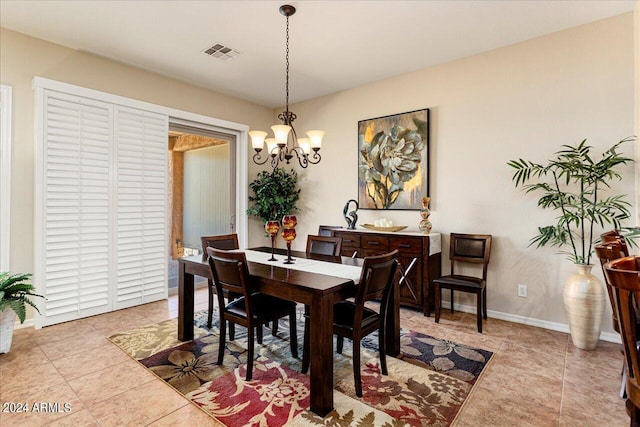 tiled dining room featuring a chandelier