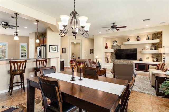 tiled dining area featuring ceiling fan with notable chandelier and built in shelves