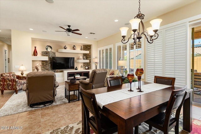 dining area featuring built in shelves, ceiling fan with notable chandelier, and light tile patterned flooring