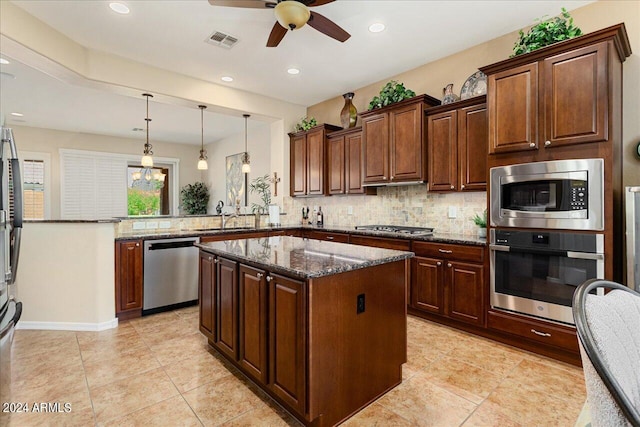 kitchen featuring ceiling fan, decorative backsplash, appliances with stainless steel finishes, light tile patterned floors, and kitchen peninsula