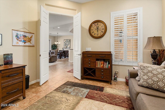 living room with a notable chandelier and light tile patterned floors