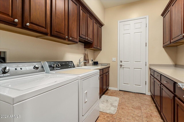 laundry room featuring light tile patterned floors, sink, independent washer and dryer, and cabinets