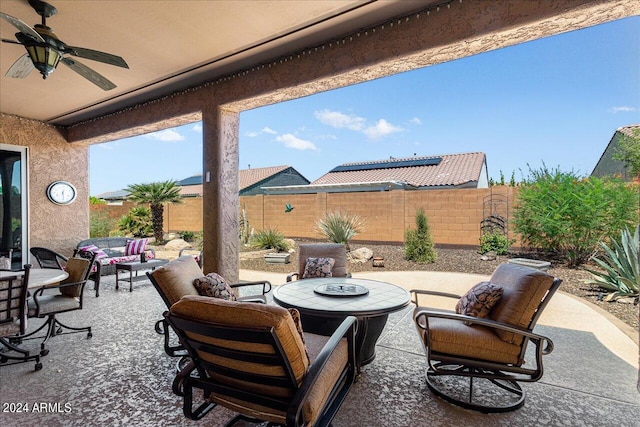 view of patio featuring ceiling fan and an outdoor living space with a fire pit