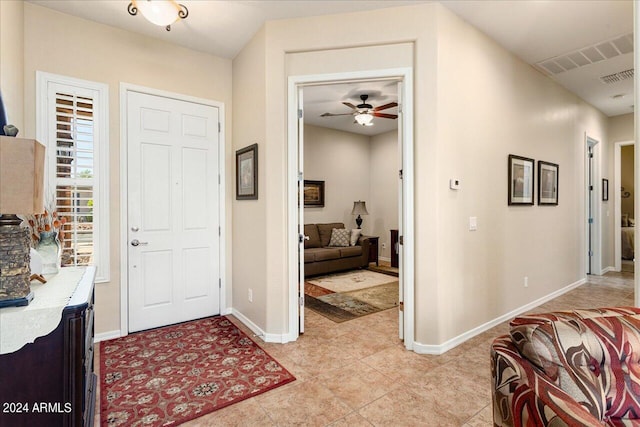 tiled entryway featuring ceiling fan