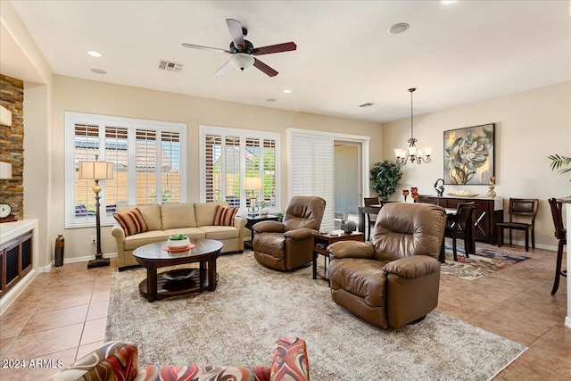 living room with ceiling fan with notable chandelier and light tile patterned flooring