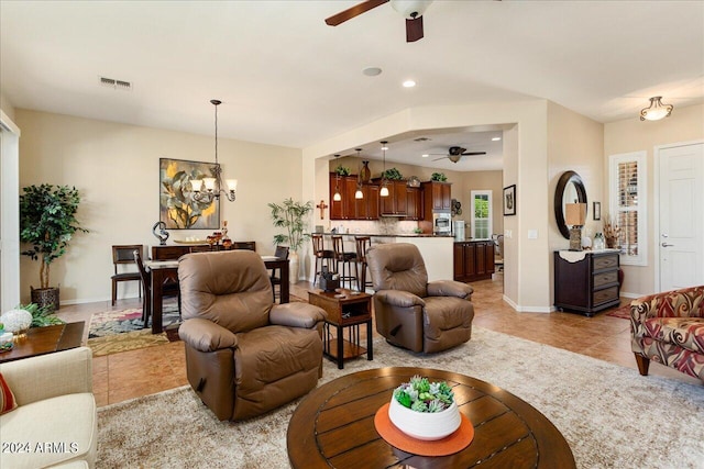 living room featuring ceiling fan with notable chandelier and light tile patterned floors