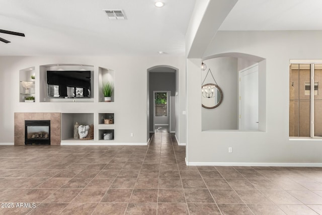 4215 W Hackamore Dr, Phoenix, AZ 85083 - unfurnished living room with built in shelves, baseboards, a tile fireplace, tile patterned flooring, and a ceiling fan