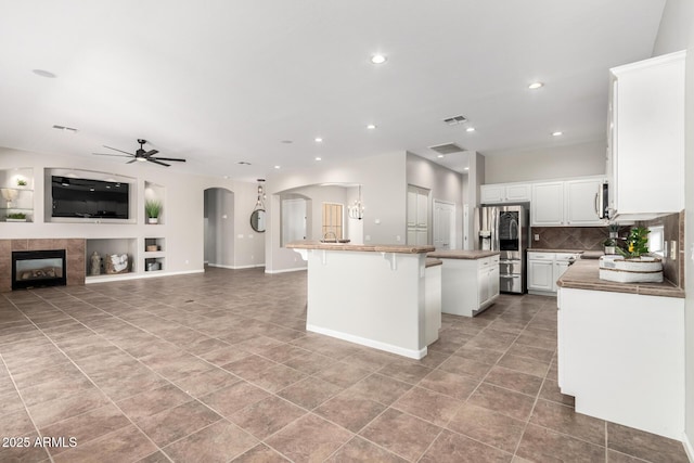 4215 W Hackamore Dr, Phoenix, AZ 85083 - kitchen with appliances with stainless steel finishes, arched walkways, a kitchen island, open floor plan, and a ceiling fan
