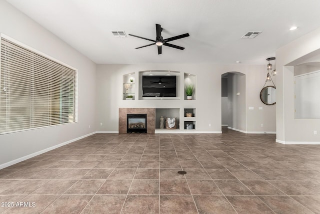 4215 W Hackamore Dr, Phoenix, AZ 85083 - unfurnished living room with ceiling fan, arched walkways, tile patterned floors, a fireplace, and baseboards