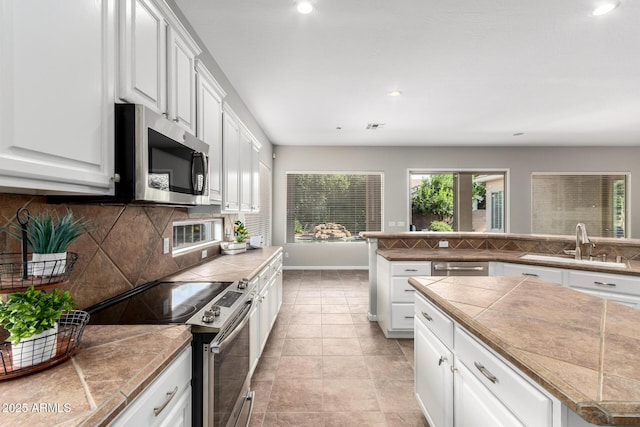 4215 W Hackamore Dr, Phoenix, AZ 85083 - kitchen featuring appliances with stainless steel finishes, decorative backsplash, white cabinetry, and recessed lighting