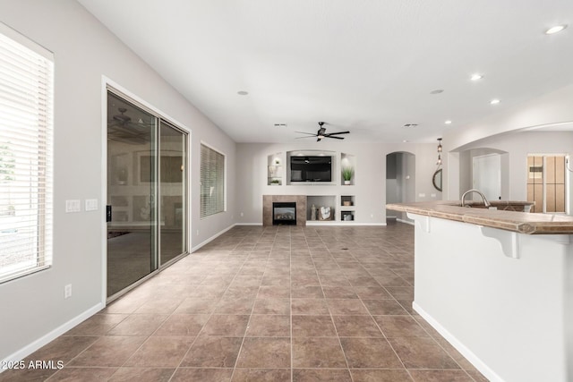 4215 W Hackamore Dr, Phoenix, AZ 85083 - unfurnished living room with a ceiling fan, plenty of natural light, arched walkways, a fireplace, and recessed lighting
