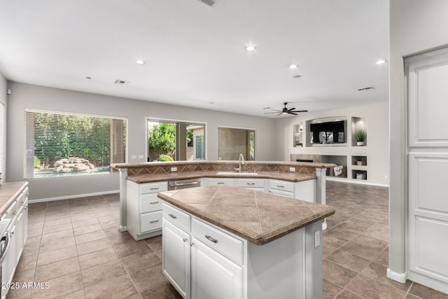 4215 W Hackamore Dr, Phoenix, AZ 85083 - kitchen featuring a center island, a sink, ceiling fan, dishwasher, and white cabinetry