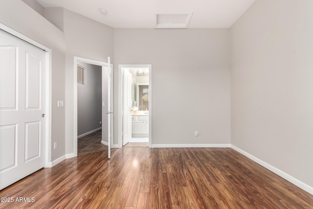 4215 W Hackamore Dr, Phoenix, AZ 85083 - unfurnished bedroom with wood finished floors, baseboards, and connected bathroom