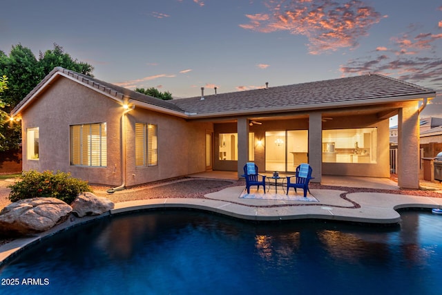 4215 W Hackamore Dr, Phoenix, AZ 85083 - back of house at dusk with a patio area, an outdoor pool, and stucco siding