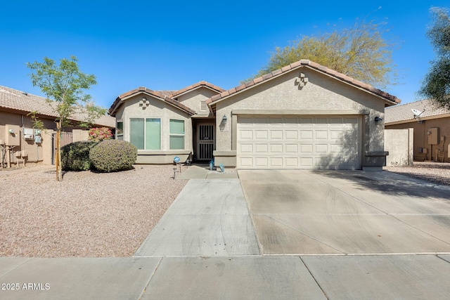 view of front facade featuring concrete driveway, an attached garage, a tile roof, and stucco siding