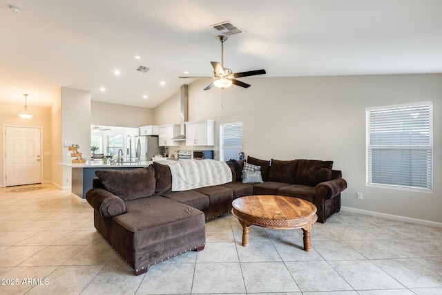 living room featuring light tile patterned floors, visible vents, and ceiling fan