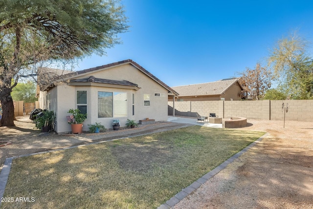 view of front of house featuring stucco siding, a patio, a fenced backyard, and a front yard