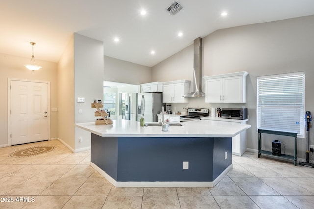 kitchen with visible vents, a spacious island, stainless steel appliances, white cabinets, and wall chimney range hood