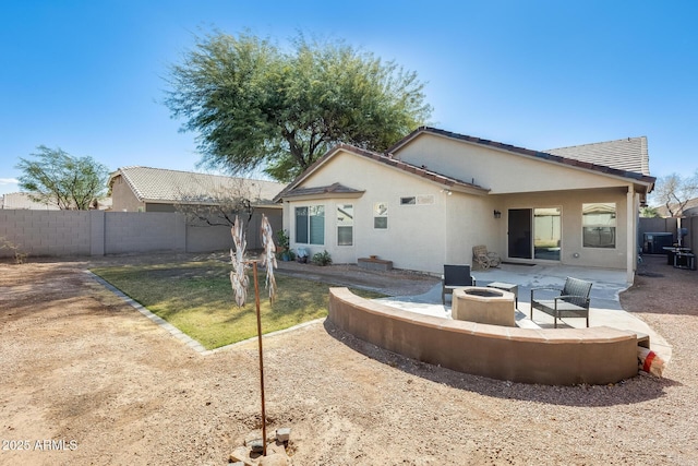 back of property with a patio area, stucco siding, fence, and an outdoor fire pit