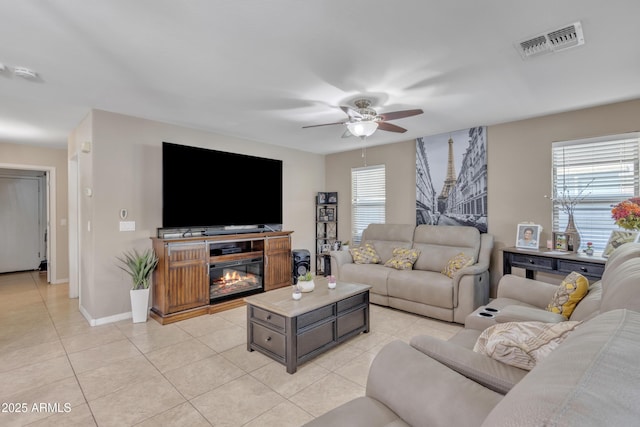 living area with a ceiling fan, light tile patterned floors, baseboards, and visible vents