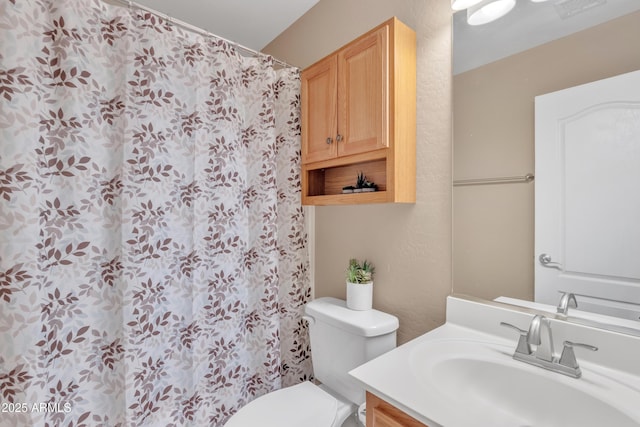 bathroom with toilet, vanity, a shower with curtain, visible vents, and a textured wall