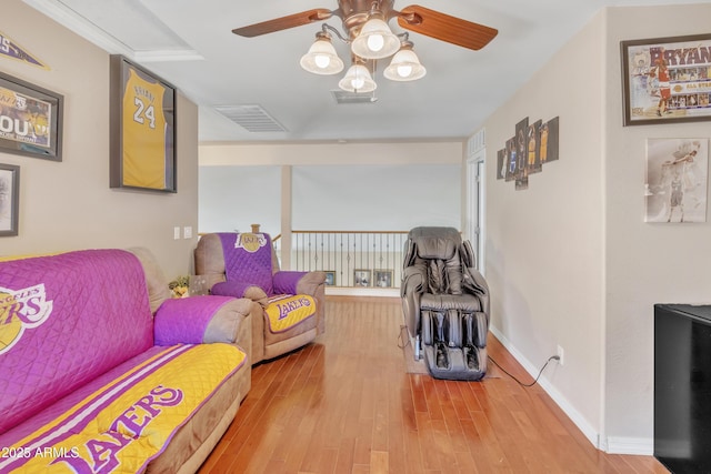living room with baseboards, visible vents, a ceiling fan, and wood finished floors