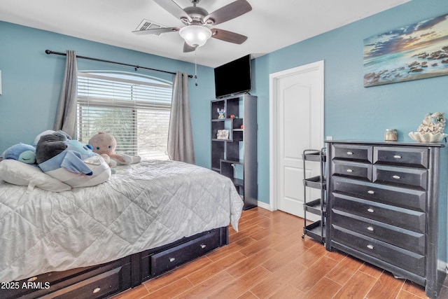 bedroom featuring baseboards, ceiling fan, and light wood-type flooring
