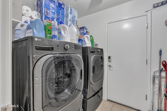 washroom featuring washing machine and clothes dryer, laundry area, and tile patterned flooring