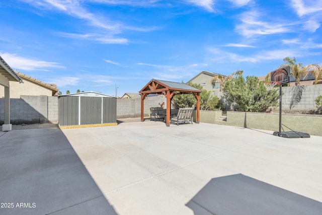 view of patio featuring an outbuilding, a storage unit, a fenced backyard, and a gazebo