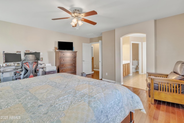 bedroom featuring arched walkways, ceiling fan, and hardwood / wood-style flooring