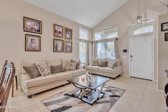 living room featuring baseboards, high vaulted ceiling, and light tile patterned floors